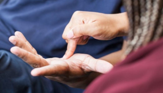 An intervenor uses print on palm to communicate with a client. 