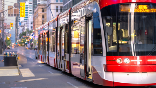 Un tramway glisse le long d'une rue animée de la ville et s'approche de l'arrêt.