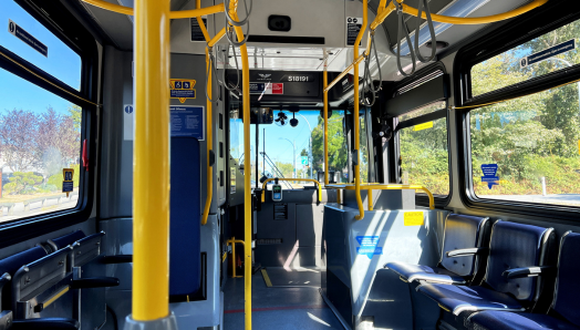 The empty interior of a bus. Rows and rows of empty seats. 