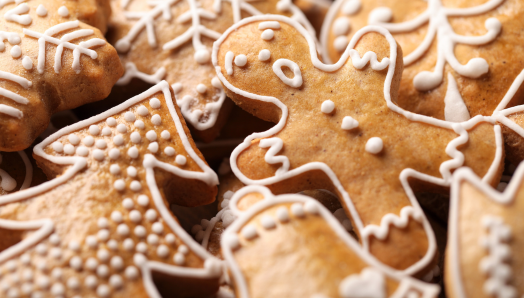 Une pile de biscuits en pain d'épices décorés avec du glaçage blanc.