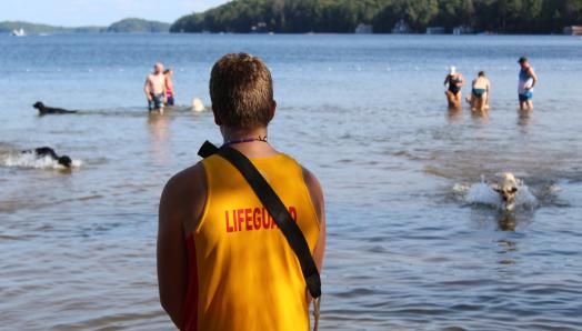 A lifeguard watching the lake while kids are playing