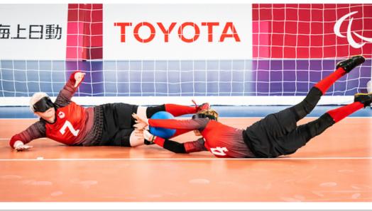 Les athlètes de goalball de l'équipe canadienne Amy Burk, à gauche, et Meghan Mahon, à droite, plongent vers un ballon devant un filet pendant les Jeux paralympiques de Tokyo 2021. Image gracieusement fournie par le Comité paralympique canadien.