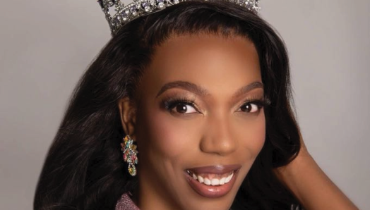 Un portrait professionnel de Shaunelle Gregory portant une robe scintillante et une couronne de concours.