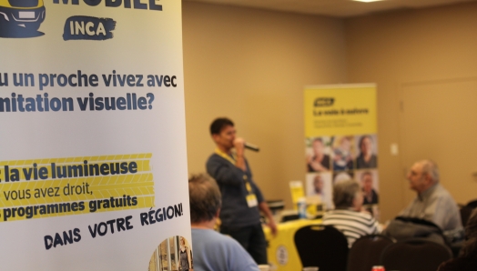 L'affiche du Hub Mobile avec en arrière plan un homme au mico devant des participants.
