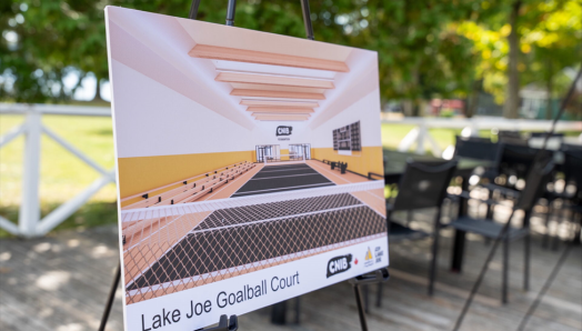 Représentation artistique du nouveau terrain de goalball du Camp Lake Joe d’INCA présentée sur un chevalet sur la terrasse du Camp Lake Joe d’INCA.